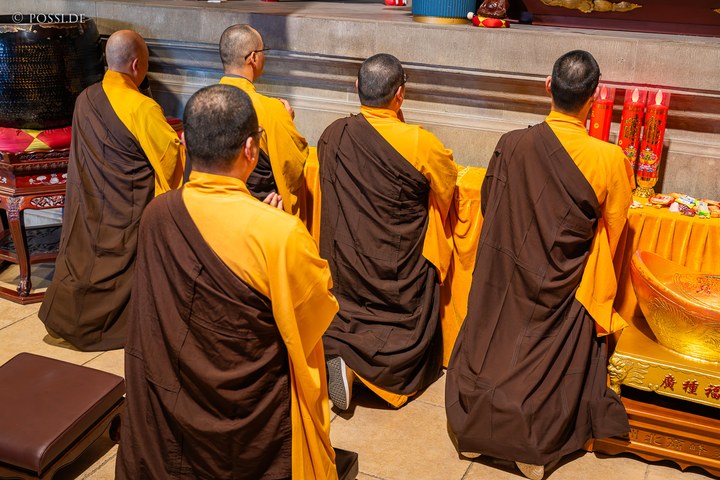 Die Mönche sitzen im Schneidersitz vor einem Altar und beten. (25.03.2025)