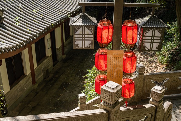 Das Bild zeigt eine traditionelle chinesische Architektur mit roten Laternen und einem steinernen Geländer, das eine idyllische Atmosphäre ausstrahlt. (25.03.2025)