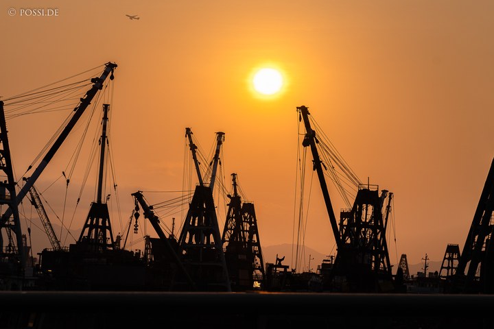 Die Sonne scheint hell und warm über den Hafen, während die Kräne stillstehen. (08.04.2025)